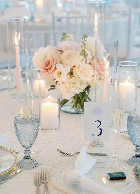 Centre de table : roses blush et blanches, bougies effilées poudrées