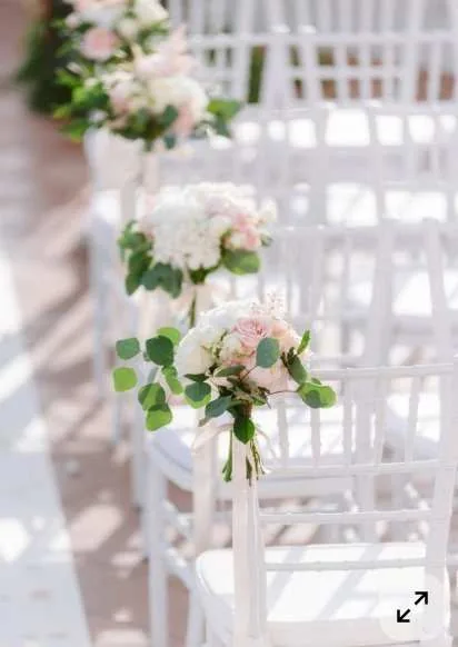 Bancs et chaises de cérémonie fleuris de roses poudrées et verdure