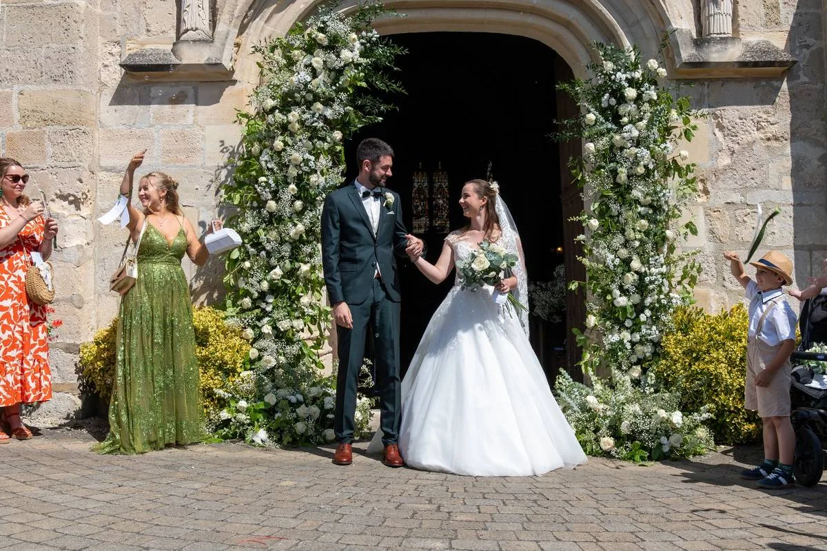 Mariage décoré par Les Fleurs d'Éléonore : arche florale de roses blanches, gypsophile et eucalyptus à la sortie de l'église